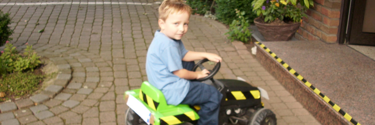 Christina's Sohn auf einem Bobbycar