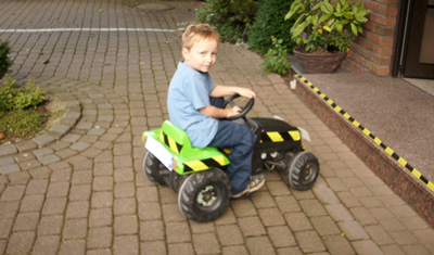 Christina's Sohn spielt auf einem Bobbycar
