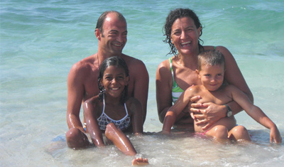 Paola sta nuotando con suo marito e i suoi figli in spiaggia.