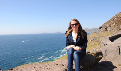 Jana sitting on the cliffs next to the ocean. 