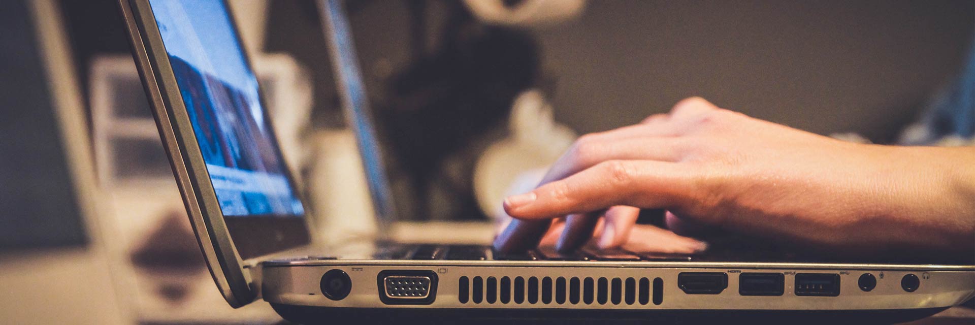 Hands typing on a laptop