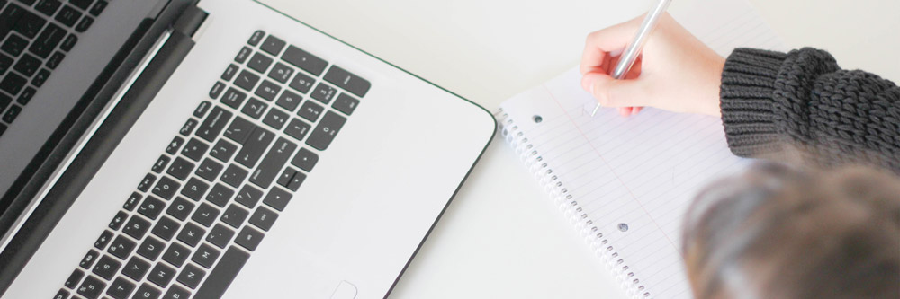 Woman taking notes with her laptop in front of her