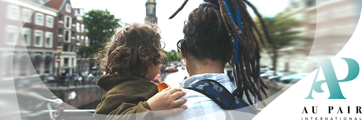 Girl and child from behind and Dutch buildings - API Logo