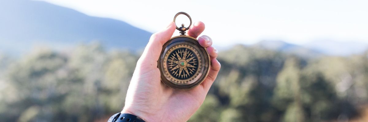 Hand holding a compass