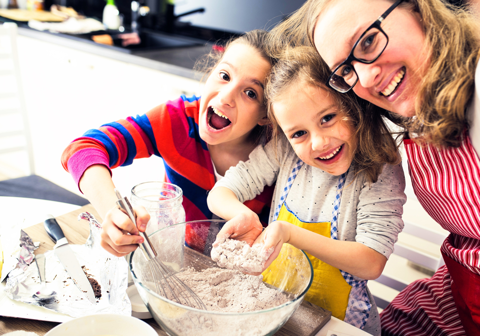 Children help with family cooking in the kitchen.