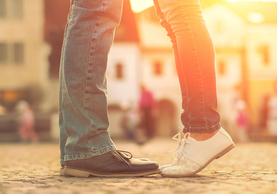 Close-up on the feet of a young couple as they embrace.