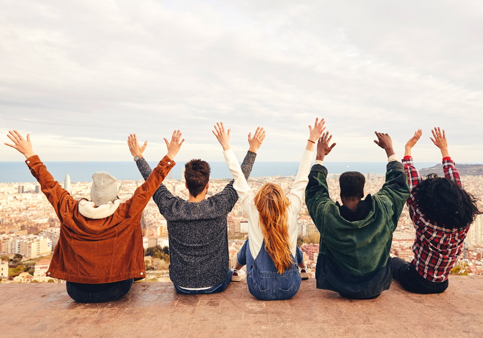 A group of young guys putting their hands up in the air