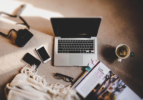 Laptop, camera, cellphone and cup of tea