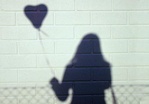 shaddow of a girl with a heart ballon in her hand