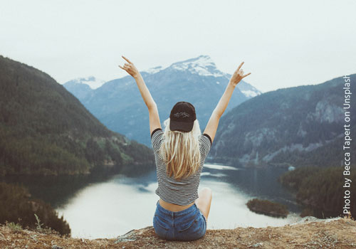 Woman in front of a lake and mountains