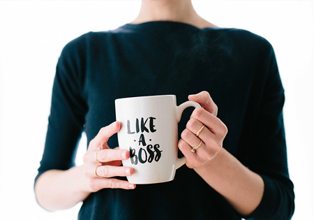 Woman with cup of coffee with text "like a boss"