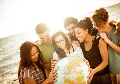 A group of young people point to a water ball globe
