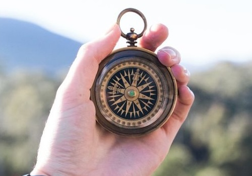 Hand holding a compass