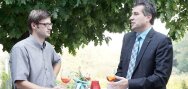 Deux assistants parlent et boivent debout à tabl